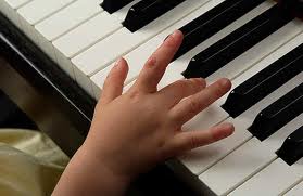 Child's hand playing the piano